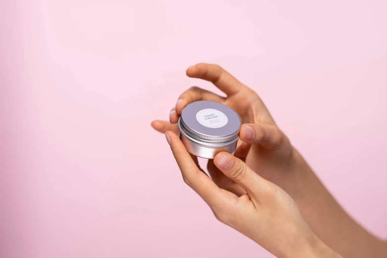 a close up of a person holding a jar of cream, grey metal body, lavender blush, 35 mm product photo”, candy pastel