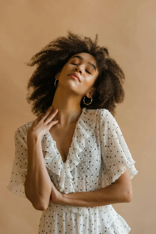 a woman wearing a white polka dot dress, trending on pexels, renaissance, natural hair, ethereal soft and fuzzy glow, hands in her hair, mixed race woman