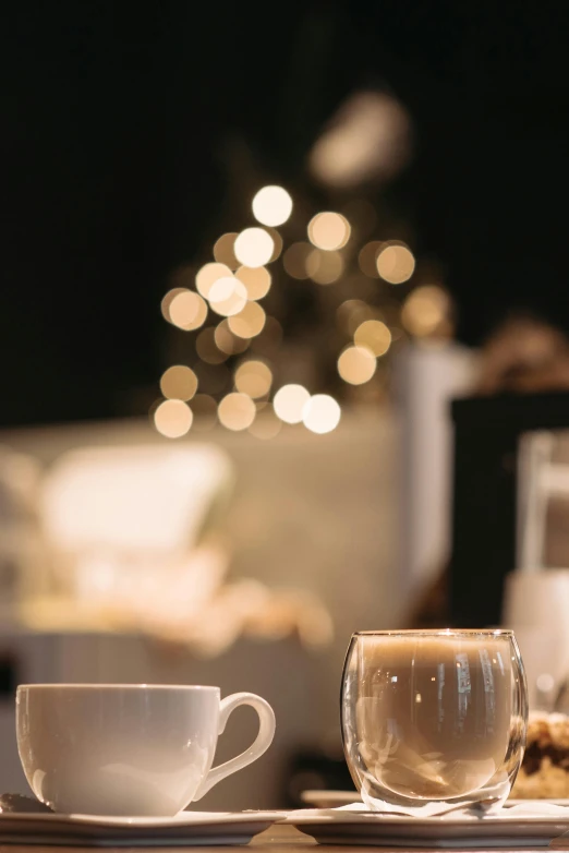 a couple of cups of coffee sitting on top of a table, subtle atmospheric lighting, sparkling spirits, winter setting, celebration of coffee products
