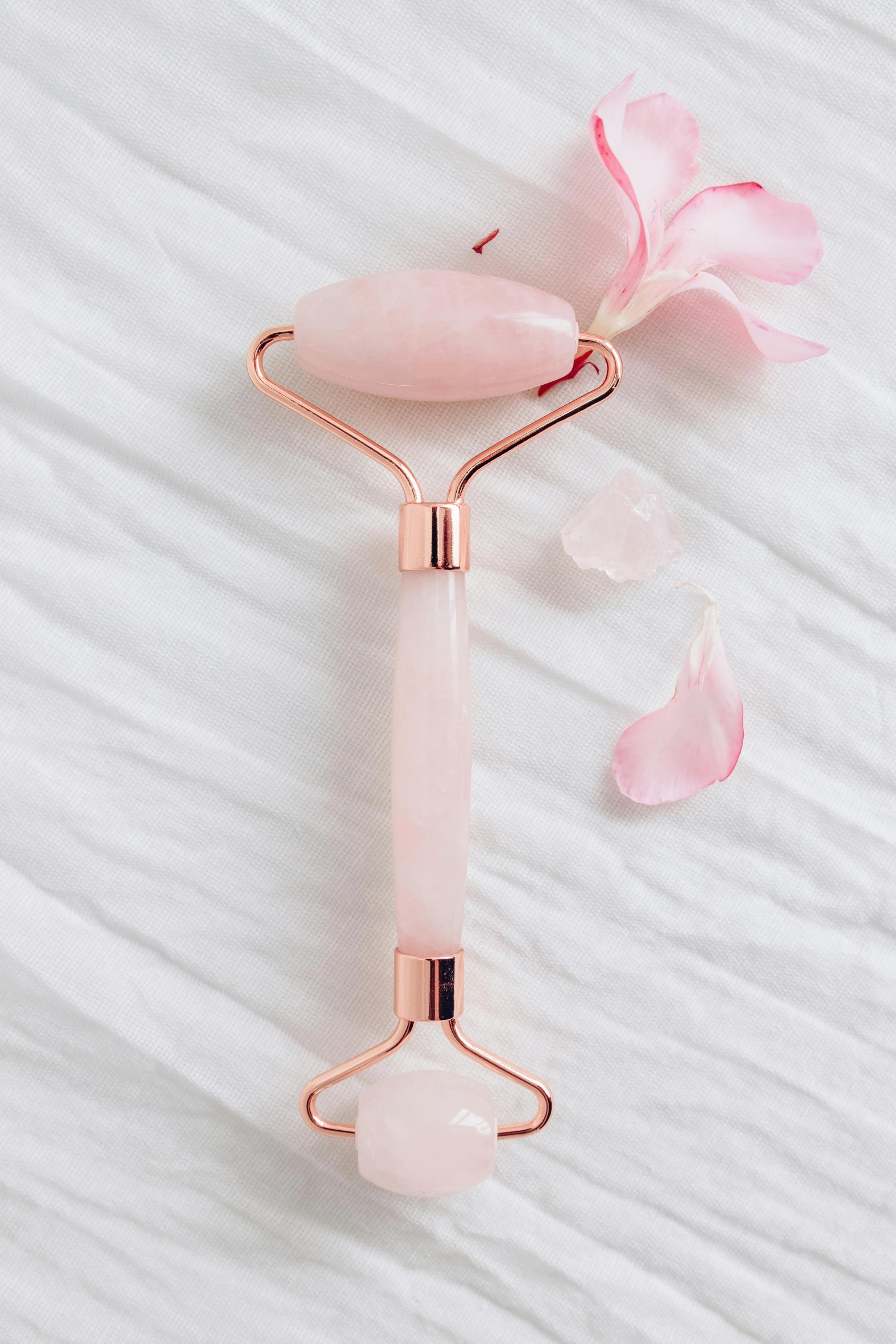 a rose quartz roller on a white background, by Julia Pishtar, glistening body, face accessories, opal petals, copper