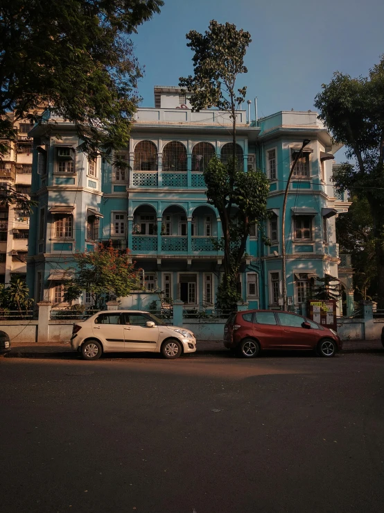 a couple of cars that are parked in front of a building, pexels contest winner, bengal school of art, rococo architecture, aquamarine windows, kalighat highly detailed, mansion
