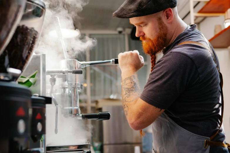 a man that is standing in front of a coffee machine, by Lee Loughridge, pexels contest winner, cooking it up, te pae, dustin panzino, bearded and built