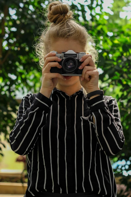 a little girl taking a picture with a camera, unsplash, visual art, wearing stripe shirt, a blond, college, woman model