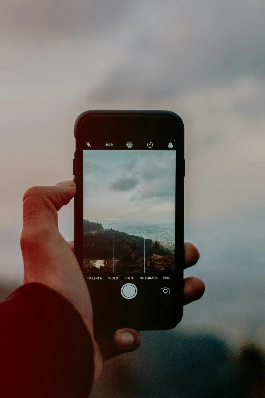 a person taking a picture with their cell phone, trending on unsplash, on a cloudy day, stylized photo, rugged, graphic”