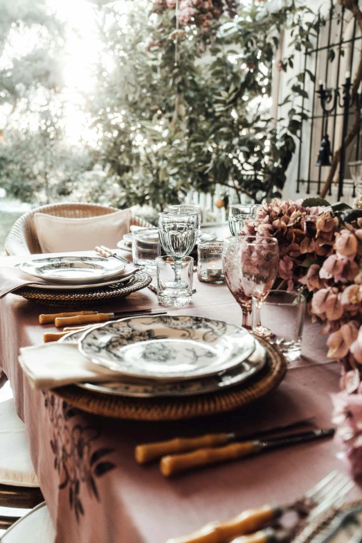 a table that has a bunch of plates on it, pexels contest winner, baroque, pink golden hour, natural light outside, dining table, garden setting