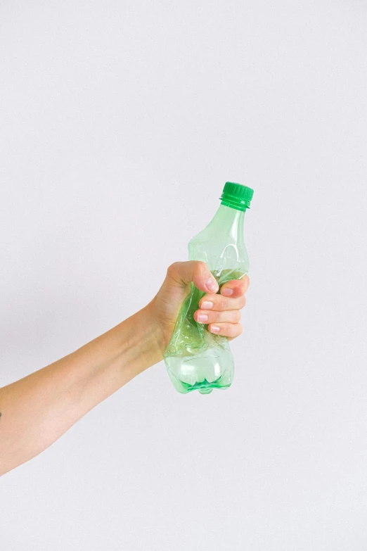 a woman holding a bottle of green liquid, by Nicolette Macnamara, plasticien, upcycled, on clear background, soda, minimalissimo