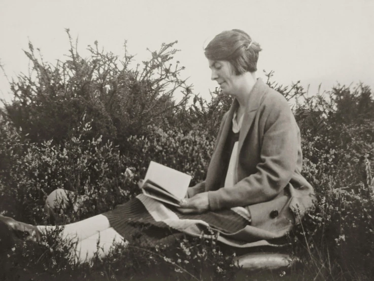 a woman sitting in the grass reading a book, by Clara Weaver Parrish, wearing 1 9 2 0 s cloth hair, press shot, eerie moorlands behind her, holding books