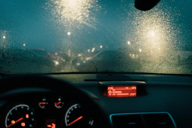 the dashboard of a car in the rain, inspired by Elsa Bleda, unsplash contest winner, visual art, humid evening, shot on hasselblad, glowing particulate, harsh sunlight