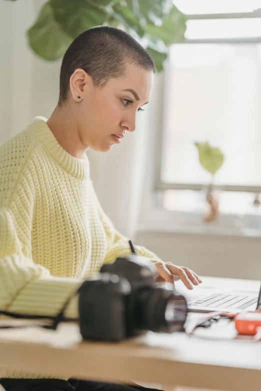 a woman sitting in front of a laptop computer, trending on pexels, visual art, full body profile camera shot, use rule of thirds, topknot, document photo