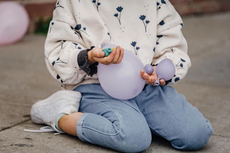 a little girl sitting on the ground with a bunch of balloons, by Helen Stevenson, trending on pexels, light purple, hands, children playing with pogs, blue soft details