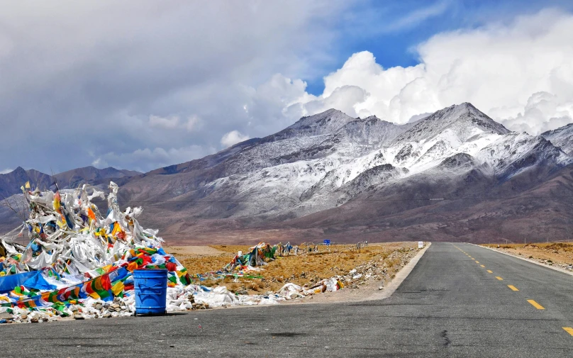 a large pile of garbage sitting on the side of a road, by Julia Pishtar, pexels contest winner, land art, tibetan inspired architecture, ice mountains afar, panorama, avatar image