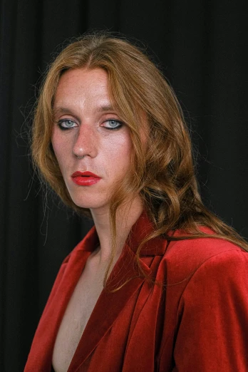 a woman in a red dress posing for a picture, an album cover, inspired by Nan Goldin, unsplash, renaissance, beth cavener, headshot photo, androgynous male, red long hair