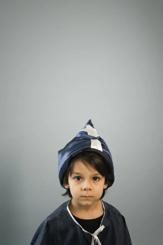 a little boy that is wearing a hat, an album cover, by Maciej Kuciara, unsplash, blue and grey, pointy hat, high quality photo, ignant