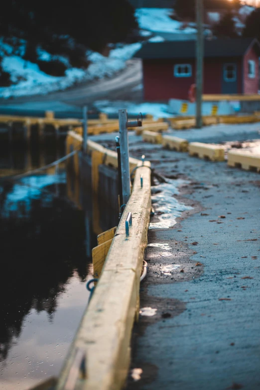 a red fire hydrant sitting on the side of a road, a picture, by Jesper Knudsen, unsplash, postminimalism, flooded fishing village, railing, buildings covered in black tar, small steps leading down