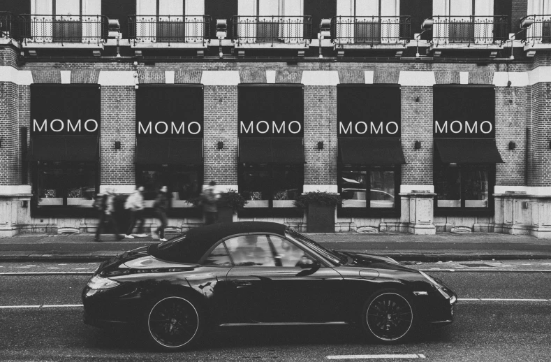 a black and white photo of a car in front of a building, by Daniel Gelon, unsplash contest winner, modernism, mooniq priem, mcbess poster, porsche 911, 🚿🗝📝