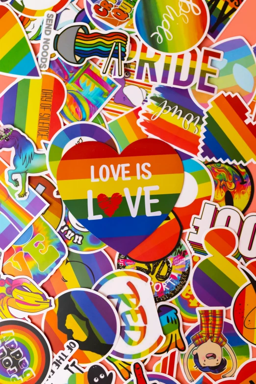 a bunch of stickers sitting on top of a table, inspired by Okuda Gensō, trending on pexels, graffiti, love is begin of all, gay rights, photograph credit: ap, camouflage made of love