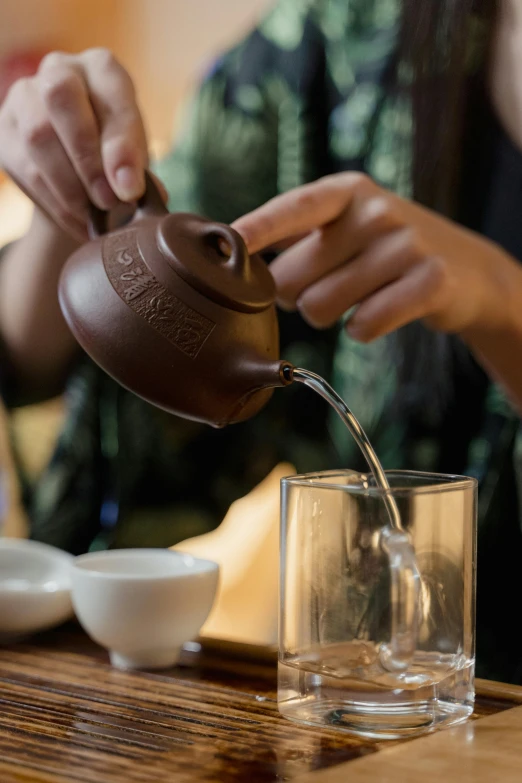 a woman pours a cup of tea into a glass, inspired by Cui Bai, melbourne, square, thumbnail, oriental