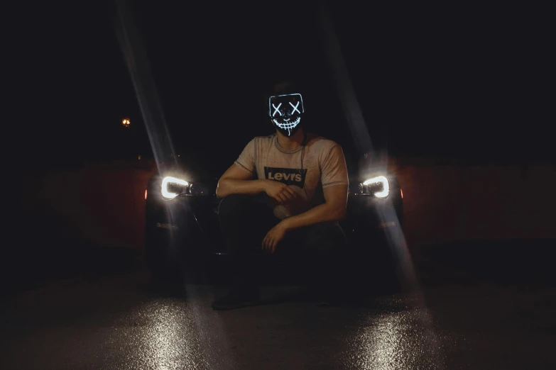 a man sitting in front of a car in the dark, skull mask, discord profile picture, headlights are on, instagram photo