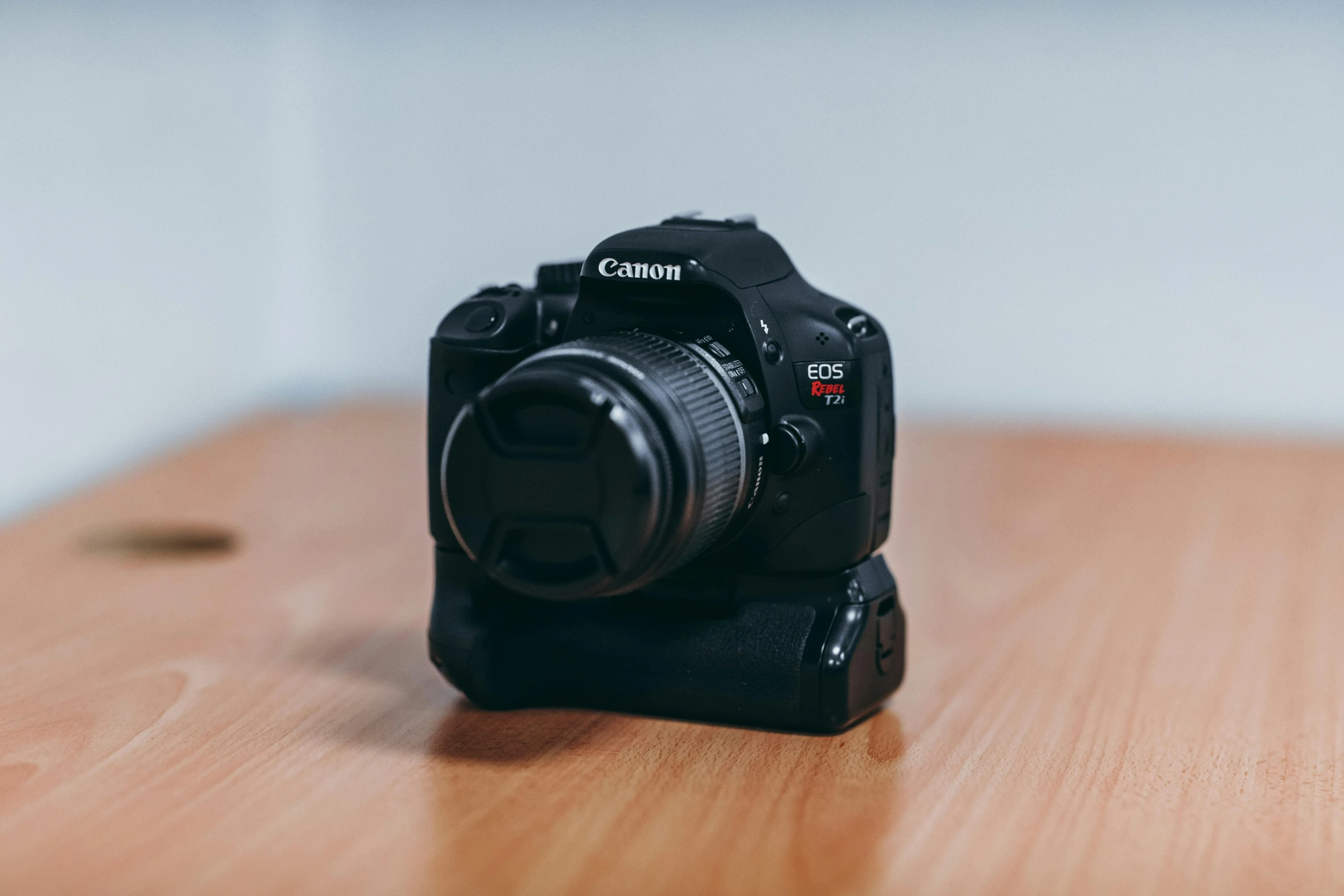 a camera sitting on top of a wooden table, unsplash, canon eos digital rebel xti, 🦩🪐🐞👩🏻🦳, set against a white background, shot with a dslr