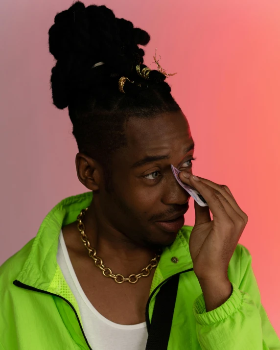 a man in a green jacket talking on a cell phone, an album cover, by Cosmo Alexander, trending on pexels, crying makeup, non binary model, riyahd cassiem, eye in forehead