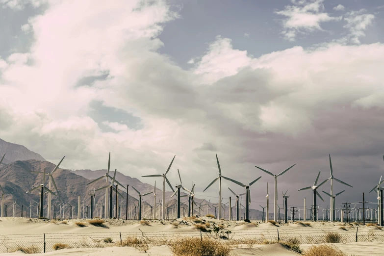 a group of wind turbines sitting in the middle of a desert, by Carey Morris, unsplash contest winner, kinetic art, palm springs, vintage color, a green, whirling gasses