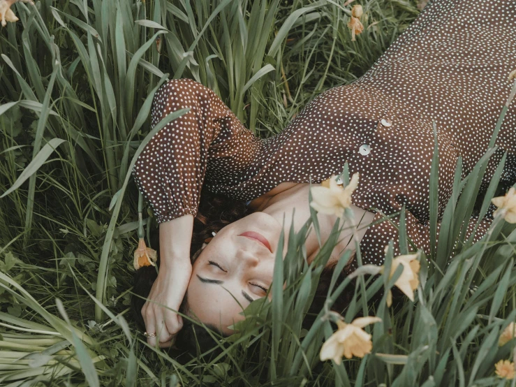 a woman laying in a field of flowers, inspired by Elsa Bleda, trending on pexels, patterned clothing, alessio albi, lush green, polka dot