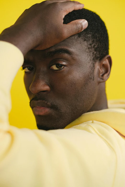 a close up of a person holding a cell phone, an album cover, yellow walls, lance reddick, ignant, beautiful young man