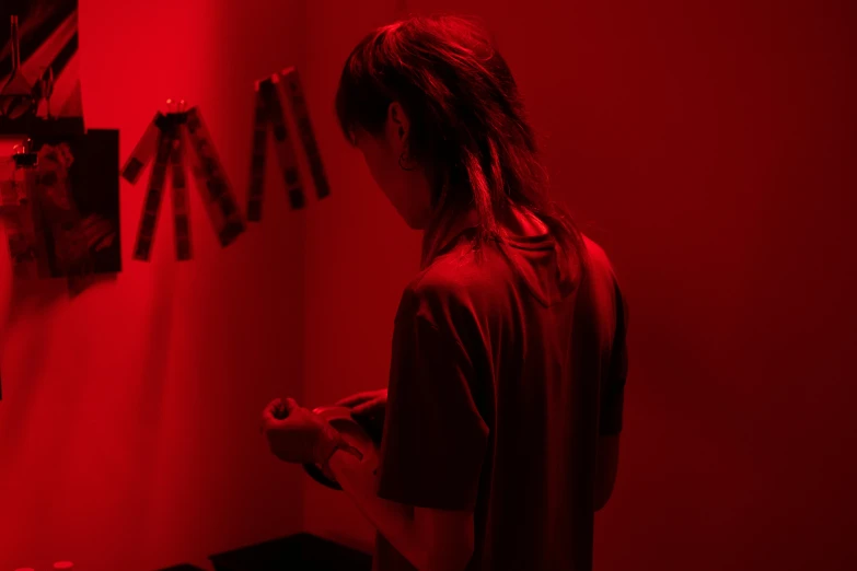 a person standing in a room with a red light, lain iwakura, tactile buttons and lights, red ribbon, ignant