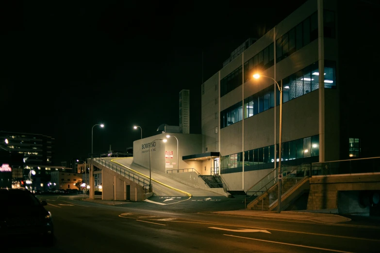 a car driving down a city street at night, by Brian Dunlop, brutalism, terminal, high resolution photo, entrance, ignant