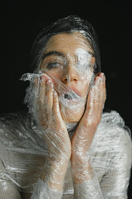 a woman covering her face with plastic wrap, inspired by Elsa Bleda, pexels contest winner, powdered wig, soap, video still, skincare