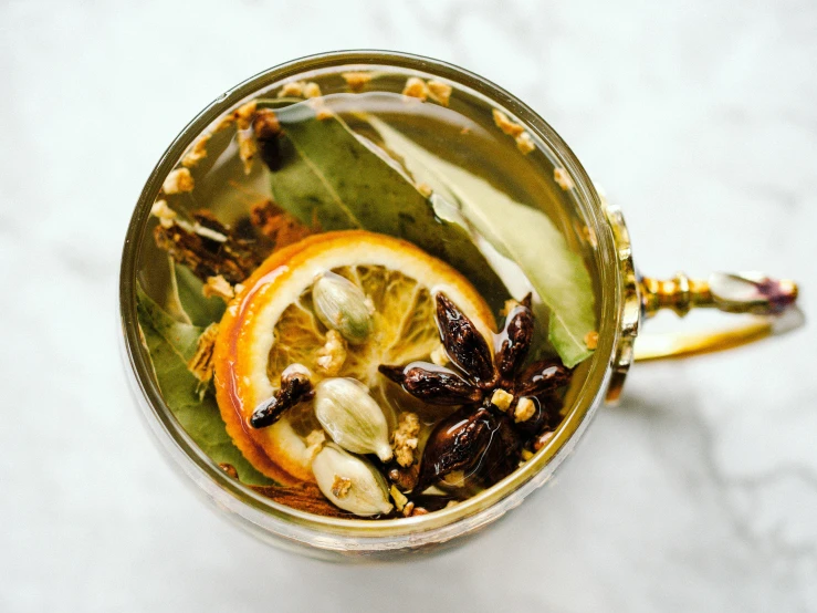 a close up of a cup of tea on a table, by Julia Pishtar, spices, aspic, epicurious, holiday season