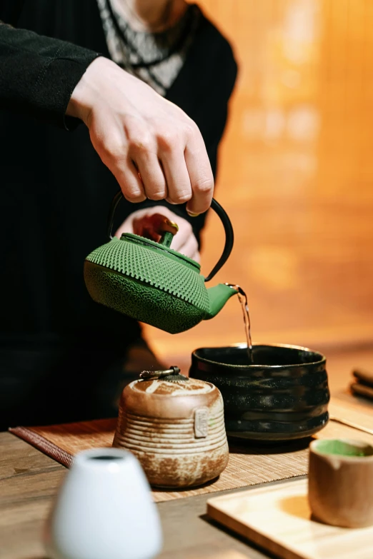 a woman pouring tea into a green teapot, inspired by Kanō Shōsenin, trending on unsplash, square, a wooden, finely textured, sharply detailed