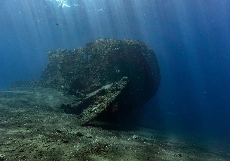 a boat sitting on top of a sandy ocean floor, at the bottom of the ocean, shipwreck, award-winning photo, mid morning lighting