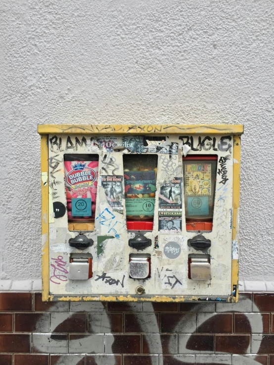 a vending machine sitting on the side of a building, inspired by Wolf Vostell, pexels contest winner, graffiti, threes, kreuzberg, gumball machine, cracked and faded in places