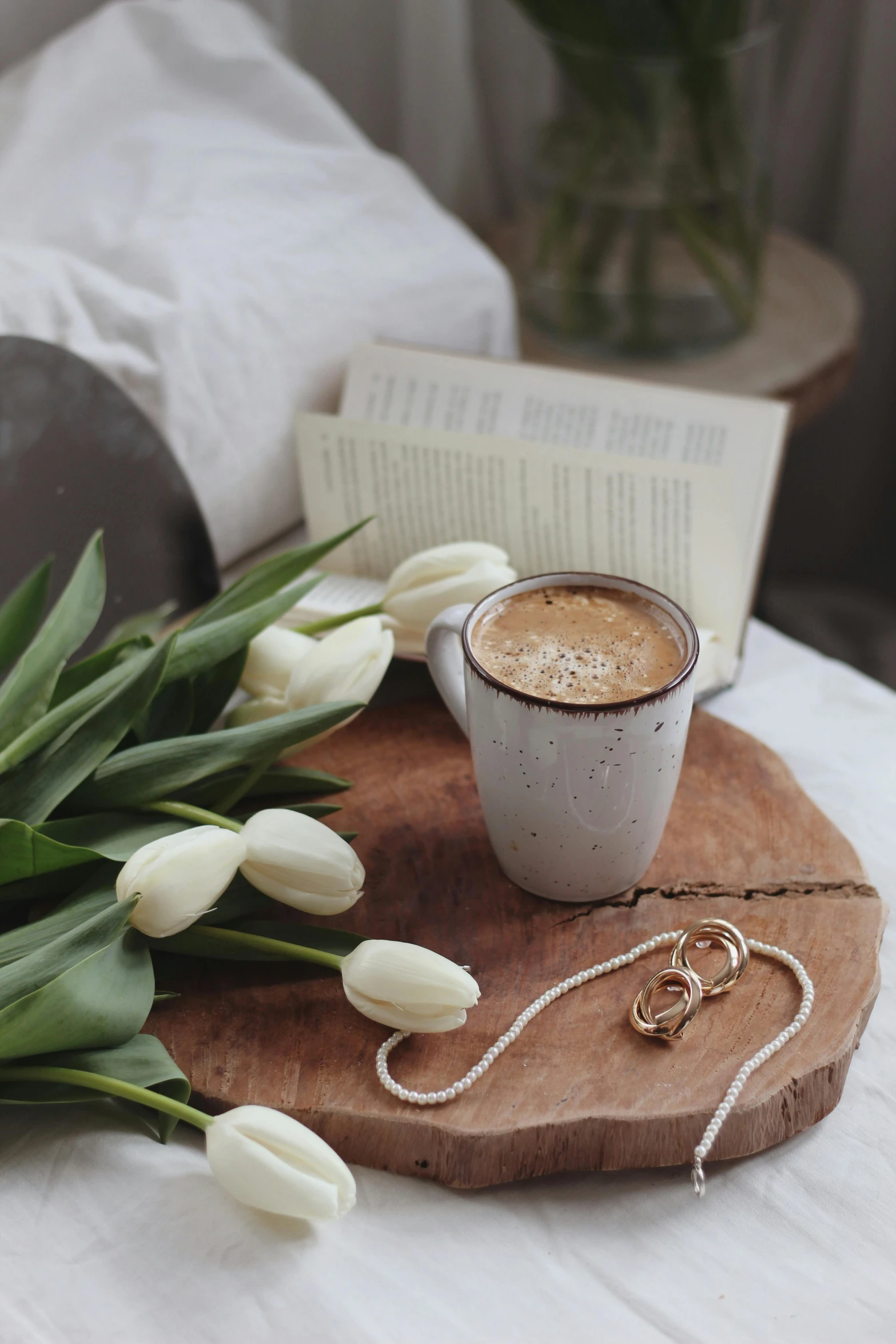 a bouquet of white tulips next to a cup of coffee, trending on pexels, romanticism, wooden jewerly, storybook style, coffee stain, cozy bed