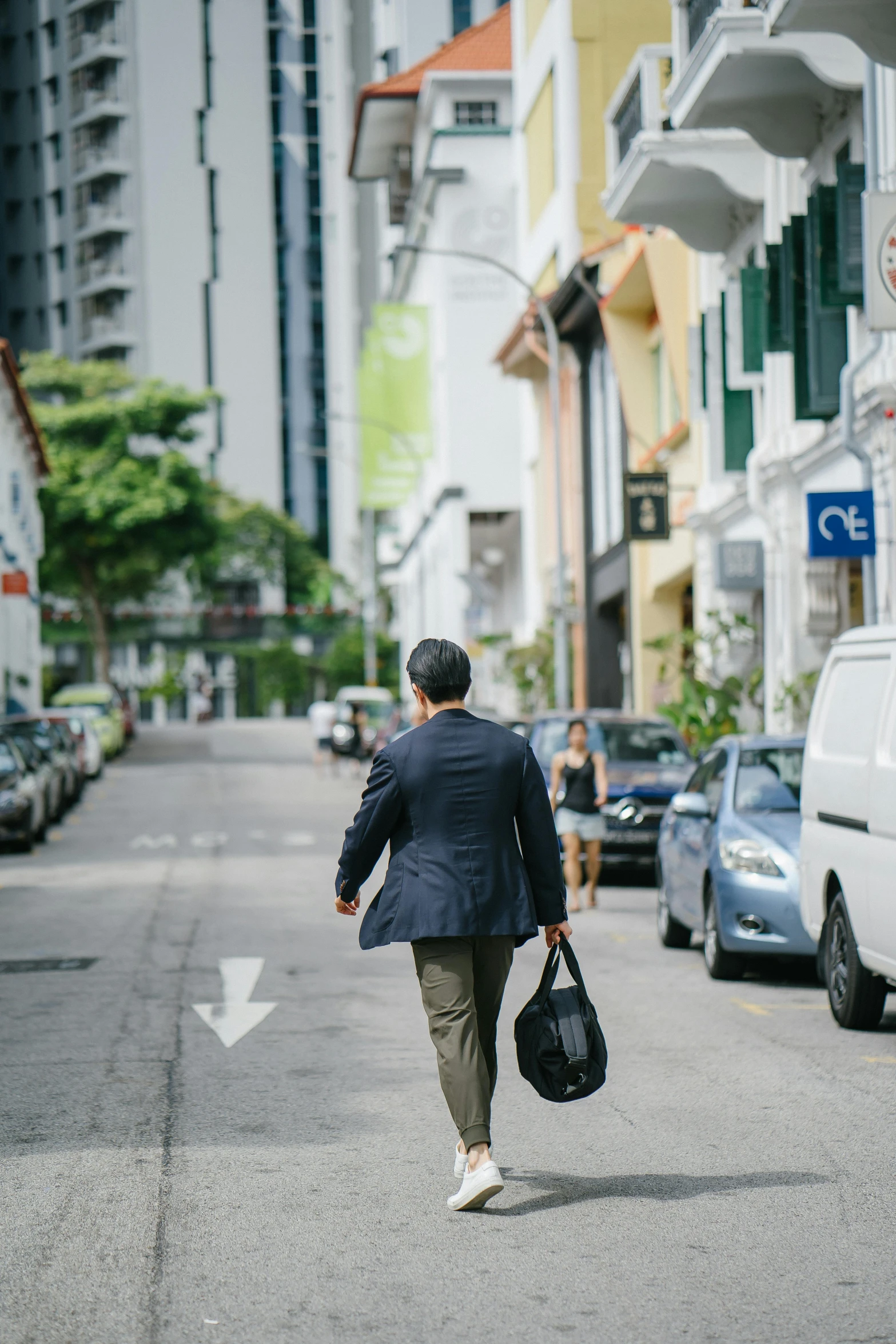 a man walking down the street carrying a bag, by Reuben Tam, unsplash, happening, singapore, subject detail: wearing a suit, al fresco, jen atkin