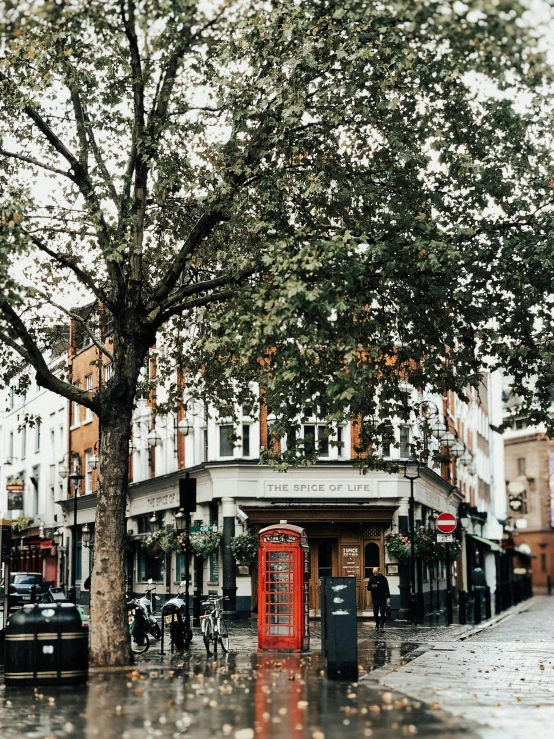 a red phone booth sitting on the side of a street, by Emma Andijewska, pexels contest winner, panoramic shot, al fresco, thumbnail, london architecture