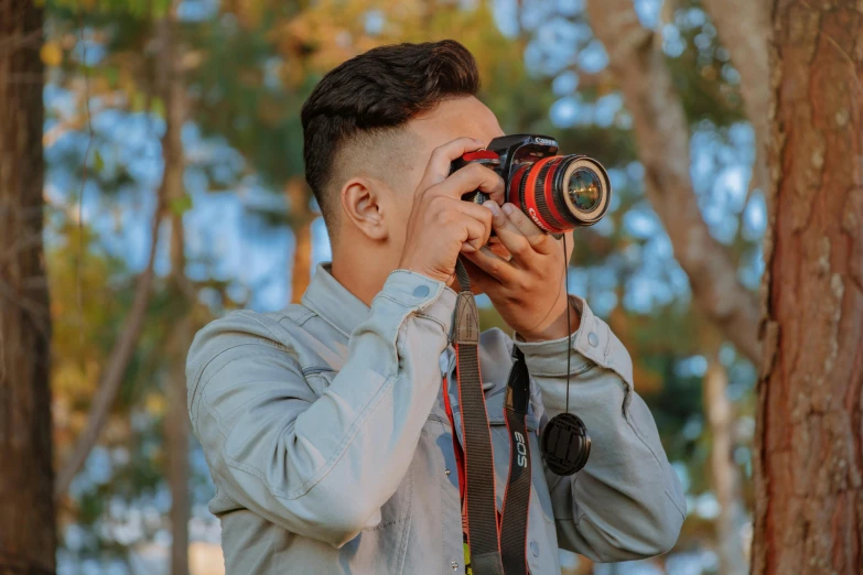 a man taking a picture with a camera, by Robbie Trevino, avatar image, outdoor photo