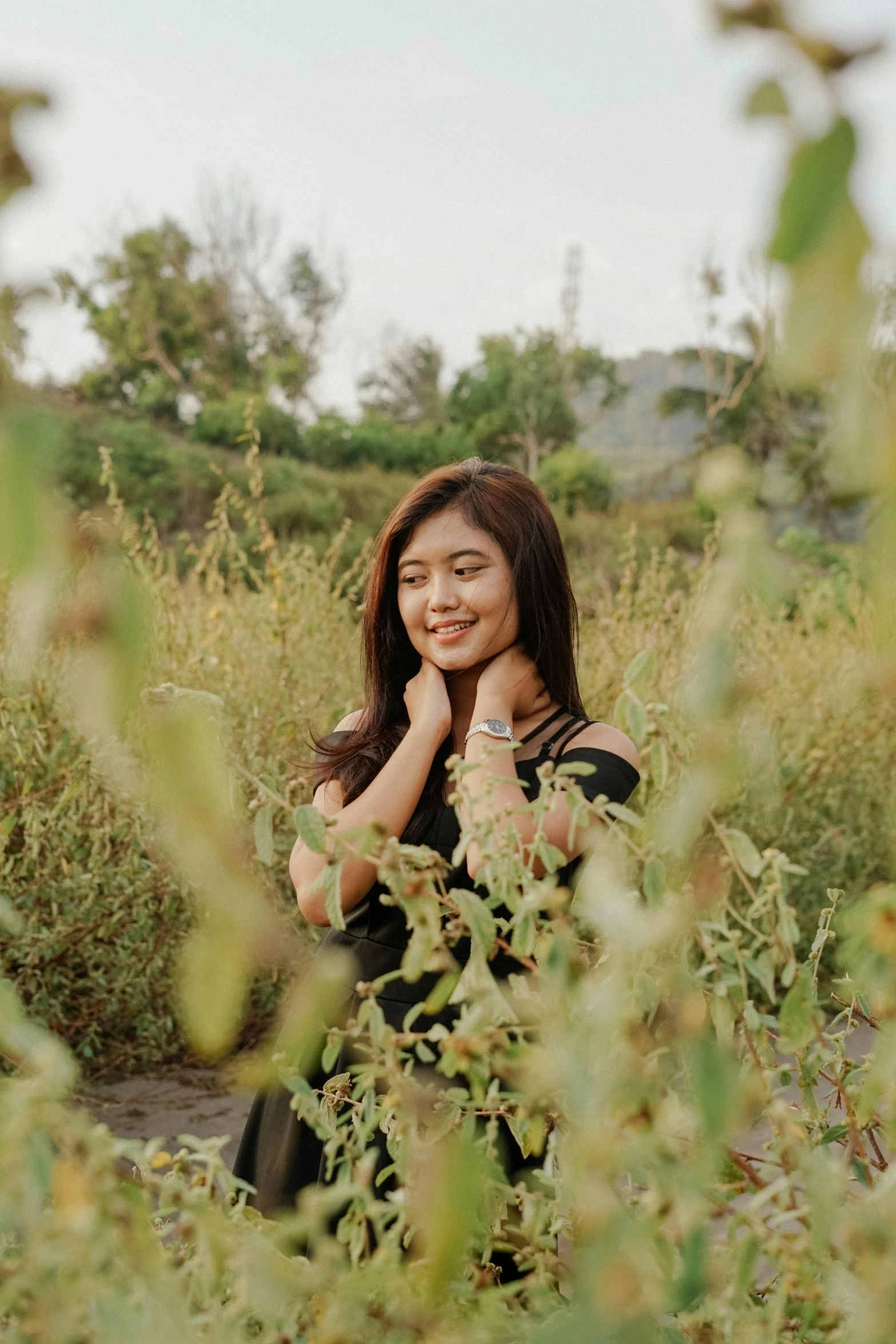 a woman in a black dress standing in a field, a picture, inspired by Kim Du-ryang, unsplash, smiling sweetly, medium format, background image, indoor picture
