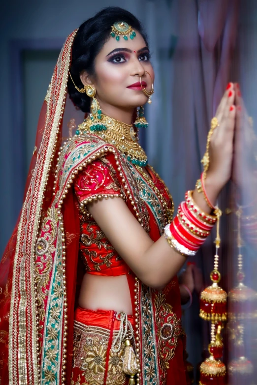 a woman in a red and gold wedding outfit, by Rajesh Soni, pexels, square, red and blue garments, advertising photo, an attractive