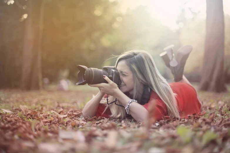 a woman laying on the ground with a camera, a picture, pixabay contest winner, during autumn, professional profile picture, photography], cute woman