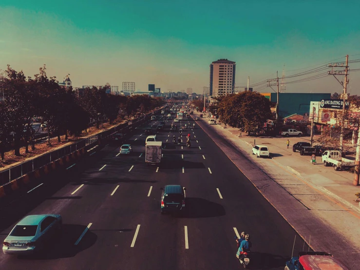 a street filled with lots of traffic next to tall buildings, by Alejandro Obregón, pexels contest winner, realism, retro effect, background image, mexico city, long highway