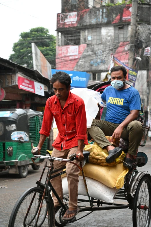 a couple of men riding on the back of a bike, an album cover, bengal school of art, wearing facemask, b - roll, street market, slide show