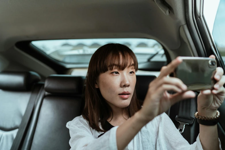 a woman taking a picture of herself in a car, inspired by Itō Shinsui, pexels contest winner, happening, square, female actress from korea, curious expression, south korean male