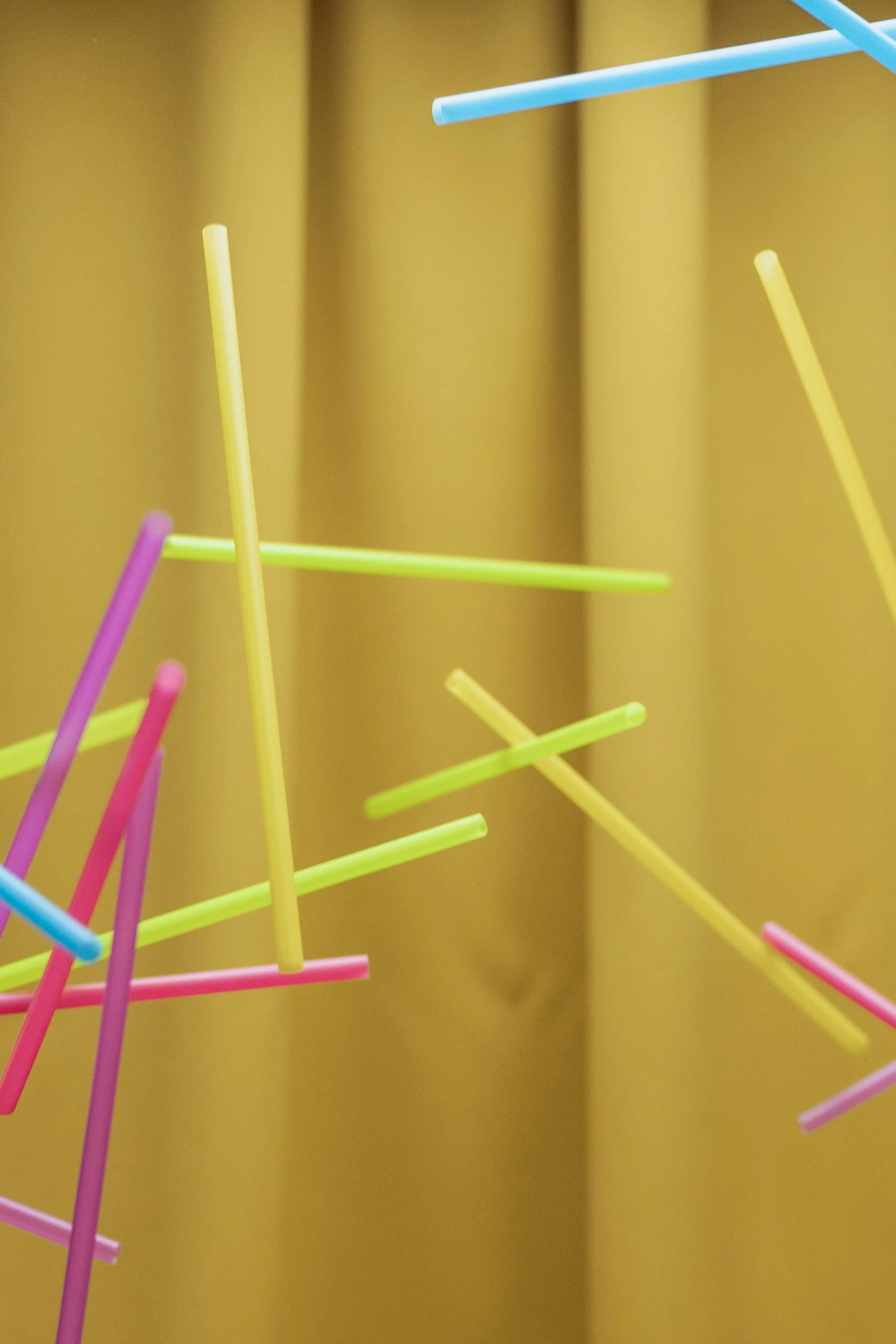 a bunch of straws sitting on top of a table, an abstract sculpture, inspired by Cerith Wyn Evans, unsplash, kinetic art, detail shot, promo image, fluo details, hay