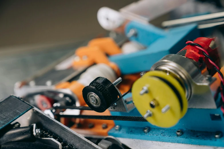 a group of tools sitting on top of a table, a tilt shift photo, by Jakob Gauermann, kinetic art, racecar, coloured in teal and orange, closeup of car engine, battery and wires