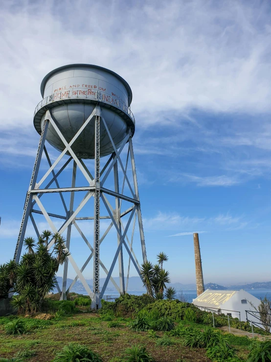 a water tower sitting on top of a lush green hillside, sutro tower in san francisco, profile image