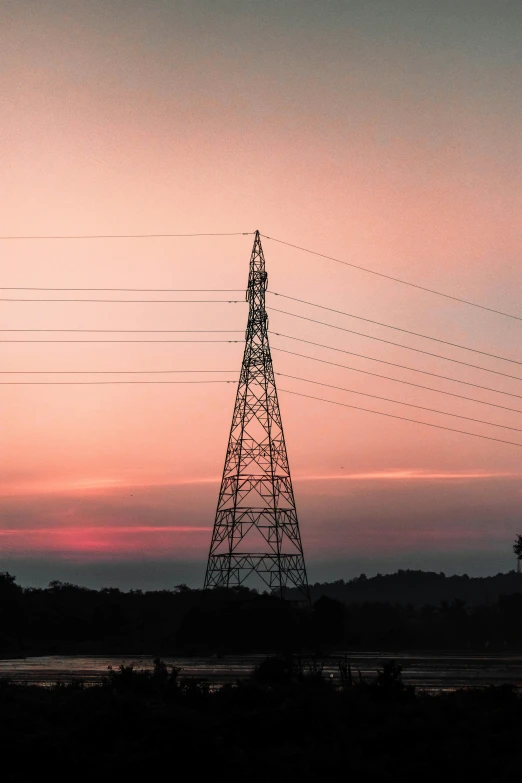 a couple of power lines next to a body of water, pexels contest winner, orange / pink sky, india, electricity highly detailed, hill