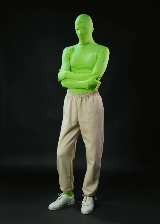 a man in a green shirt standing with his arms crossed, inspired by Vanessa Beecroft, trending on zbrush central, zentai suit, high waist sweatpants, slimer, promotional image