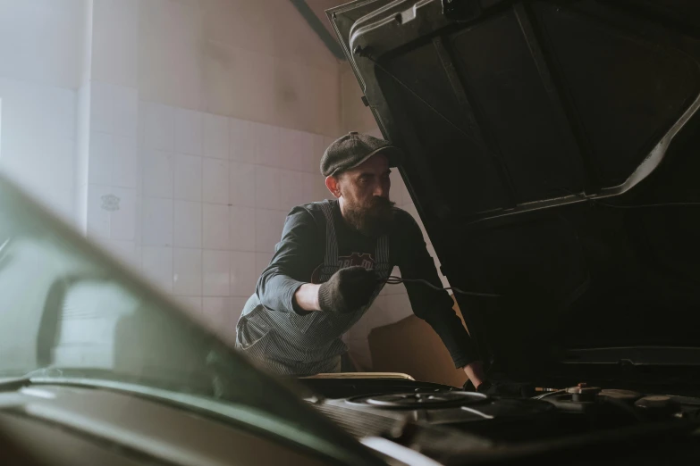 a man working on a car in a garage, by Thomas Häfner, pexels contest winner, renaissance, vintage vibe, upset, grey, thumbnail